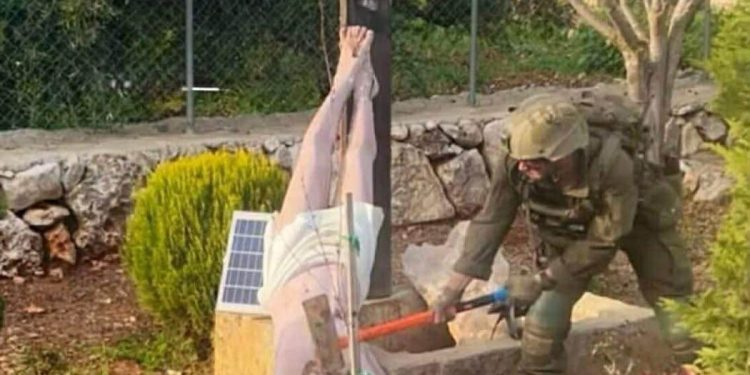 صورة تفضح أشياء كثيرة…جندي صهيوني يحطم تمثالاً للسيد المسيح في مرج عيون